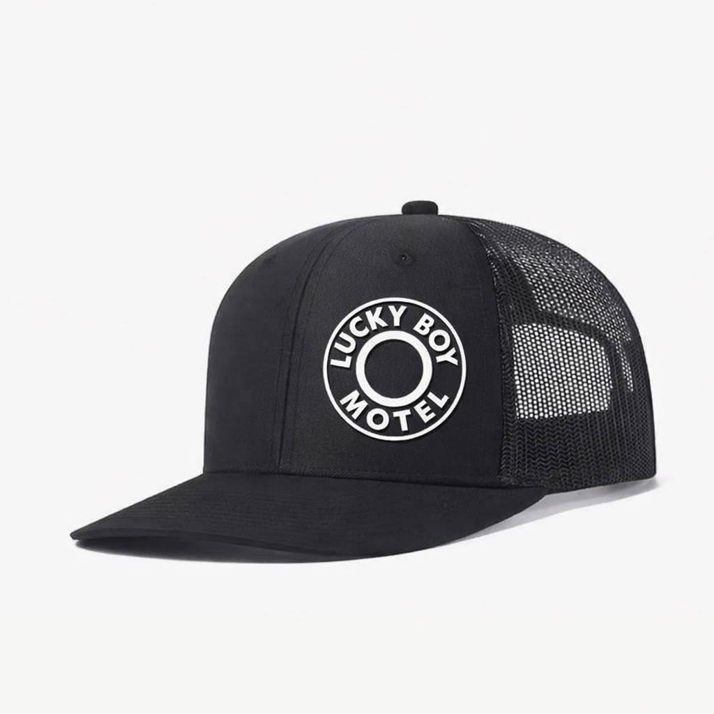 Black Lucky Boy Motel trucker cap with white mesh back.